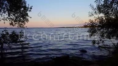 夏日清晨美丽的湖水景色。 黎明时分，红橙色的宁静湖滨风光